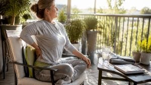 Woman massaging spine pain at home