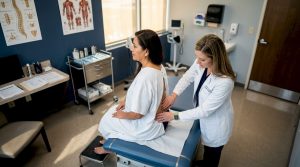 Physician examining patient for early pain treatment
