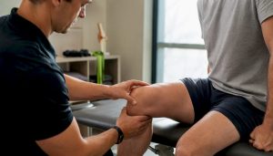 Physical therapist assessing a patient's knee