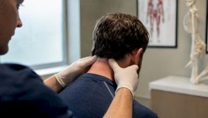 Clinician palpating base of patient's skull