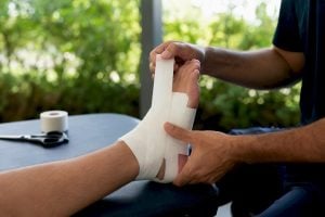 Hands taping athlete's ankle clinically