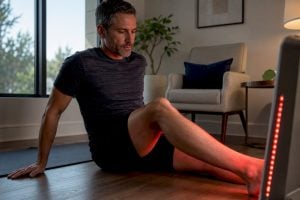 Adult using red light therapy at home