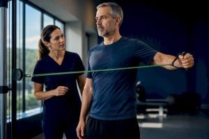 Adult performing supervised shoulder rehabilitation exercise