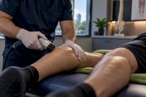 Clinician applying shockwave therapy to calf