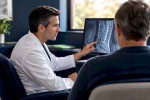 Physician and patient reviewing spine imaging
