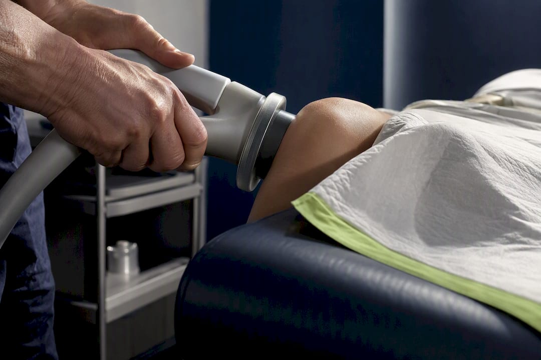 EMTT applicator positioned beside patient knee