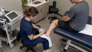 Clinician applying shockwave therapy to a heel