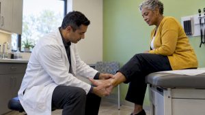Clinician assessing a patient's ankle movement