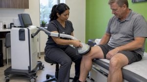 Clinician positions EMTT applicator over a knee